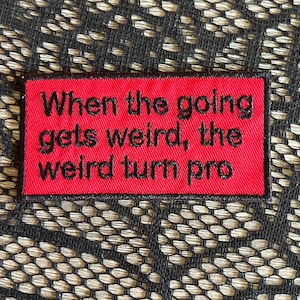 May include: A red rectangular patch with black embroidered text that reads "When the going gets weird, the weird turn pro." The patch is set against a textured background.