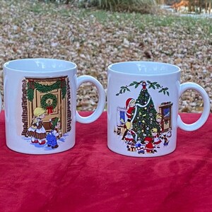 May include: Set of four white ceramic mugs with Christmas scenes. Each mug features a different scene with children and winter imagery. The mugs have a handle on the right side.