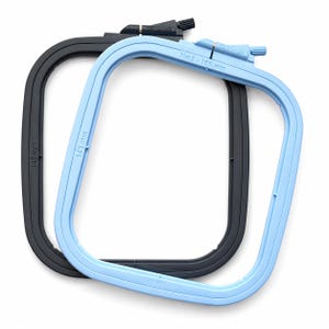 May include: Two square embroidery hoops with rounded corners, one black and one light blue. Each hoop features a tension adjustment screw at the top and embossed text reading 145 mm on the black frame and No:2 - 165 mm on the light blue frame.