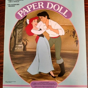 May include: A paper doll book featuring Ariel and Prince Eric from Disney's The Little Mermaid. The book includes precut fashions and two dolls. The cover features a colourful illustration of Ariel and Prince Eric dancing.