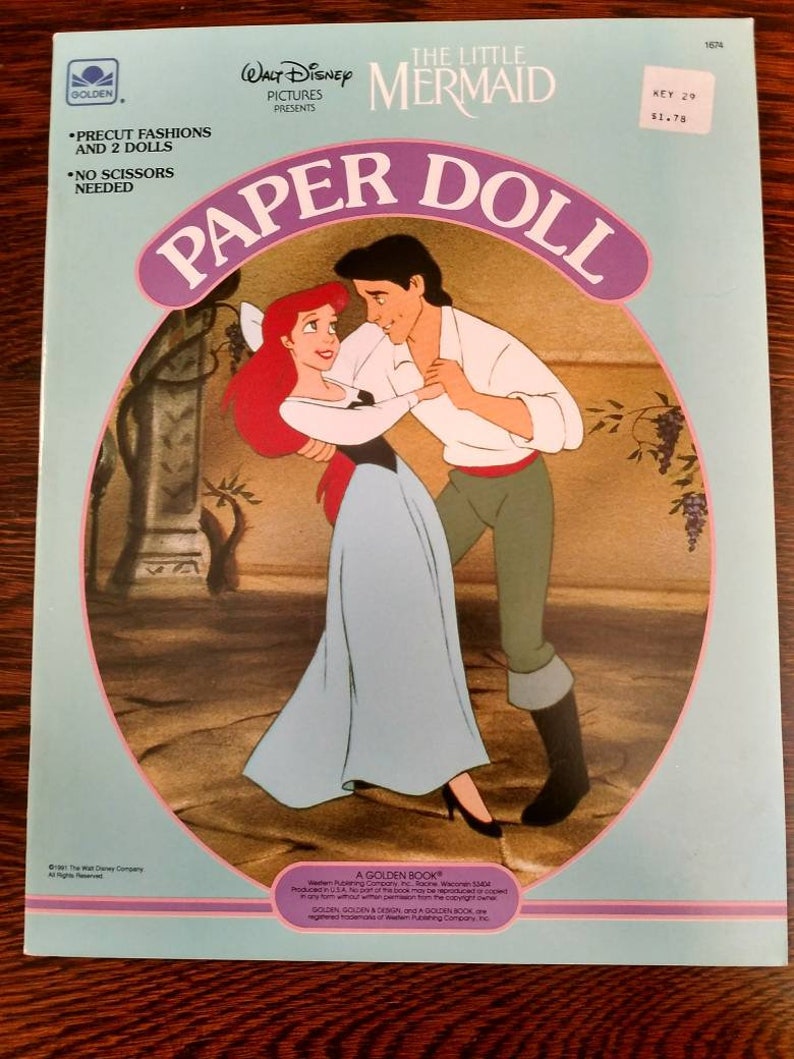 May include: A paper doll book featuring Ariel and Prince Eric from Disney's The Little Mermaid. The book includes precut fashions and two dolls. The cover features a colourful illustration of Ariel and Prince Eric dancing.