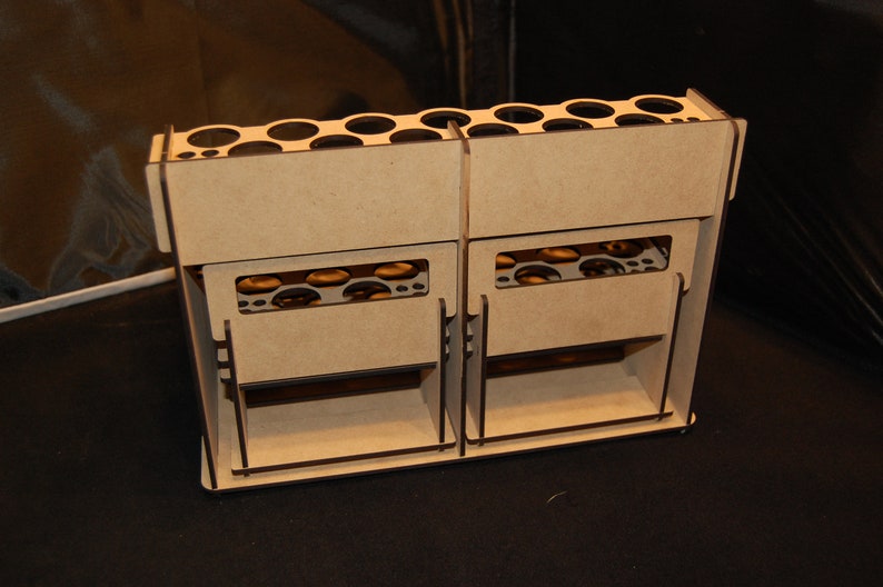 May include: A light brown wooden organizer with multiple compartments. The organizer has a series of circular holes at the top and rectangular slots on the front. It appears to be designed for storing small items.