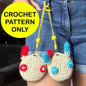 May include: Two crocheted plushie toys with red, blue, and white details. The toys are attached to a yellow string and are hanging from a person's jeans. The image text reads "CROCHET PATTERN ONLY".
