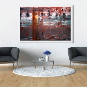 May include: Two gray armchairs with a glass coffee table and a vase of blue flowers in front of a white wall with an abstract painting hanging above the table.