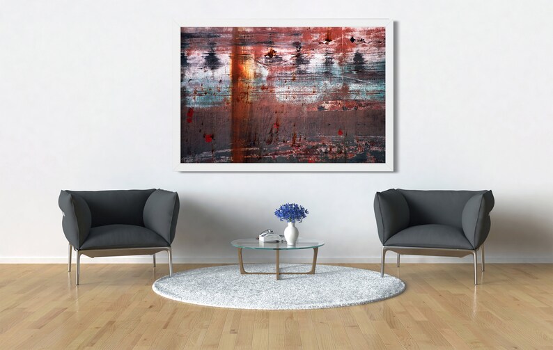 May include: Two gray armchairs with a glass coffee table and a vase of blue flowers in front of a white wall with an abstract painting hanging above the table.