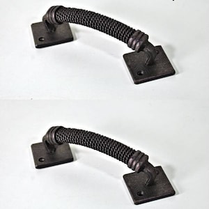Könnte beinhalten: Zwei dunkelbronzefarbene Schrankgriffe. Jeder Griff hat eine quadratische Basis und einen gebogenen, strukturierten Griff. Der Text "Handles: 2 pcs" ist sichtbar. Geeignet für Möbelrestaurierung oder Neubauten.