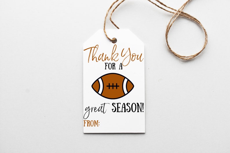 K&ouml;nnte beinhalten: Wei&szlig;er Geschenkanh&auml;nger mit braunem Band. Der Anh&auml;nger hat eine braune Fu&szlig;ballabbildung und den Text "Thank You for a great SEASON! FROM:"