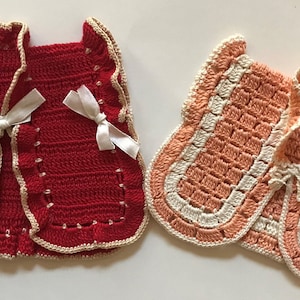 May include: Two crocheted vests, one red with white ribbon ties and one peach with white trim.