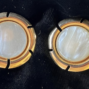 May include: A pair of gold-toned cufflinks with white mother-of-pearl insets.