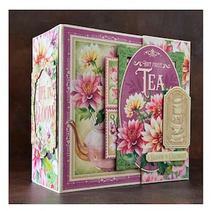 May include: A pink and green scrapbook with a floral design and the text "But first, Tea" and "A Season to Celebrate".