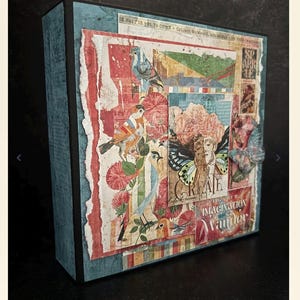 May include: A decorative box with a collage design. The box features a teal blue exterior and a front panel with torn paper, bird illustrations, and the words "CREATE" and "IMAGINATION Wander". The overall color scheme includes red, blue, and beige.