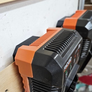 May include: Two black and orange power tool batteries with the word "RIDGID" printed on the side.