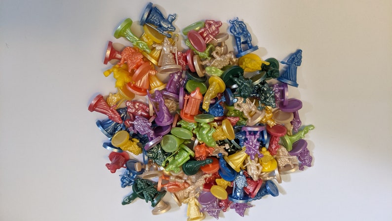 Pode incluir: Uma cole&ccedil;&atilde;o de pe&ccedil;as de jogo de pl&aacute;stico coloridas, com v&aacute;rios personagens e designs. As pe&ccedil;as s&atilde;o de v&aacute;rias cores, incluindo vermelho, azul, verde, amarelo e roxo.
