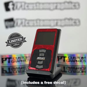 May include: A red and black air suspension controller with a digital display and a limited edition label. The controller is on a black stand and includes a free decal.