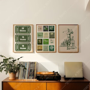 May include: Three framed prints on a white wall above a wooden cabinet. The prints are all green and white and feature golf-themed imagery. The leftmost print has three tickets with the text "18 Holes" on each. The middle print has a grid of nine smaller images, each with a different golf-themed design. The rightmost print shows a golfer in a green and white outfit swinging a golf club.