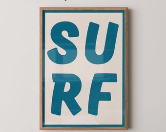 以下が含まれることがあります： クリーム色の背景に、ターコイズ色の文字で「SURF」と書かれたフレーム付きアートプリント。 フレームは明るい茶色です。 上部には「Physical Print」、下部には「Whiskey and Honey」と書かれています。 壁の装飾。
