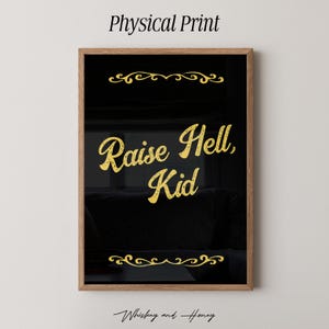 Könnte beinhalten: Gerahmter Kunstdruck mit schwarzem Hintergrund und goldenem Text "Raise Hell, Kid". Der Druck befindet sich in einem Holzrahmen und enthält dekorative goldene Verzierungen oben und unten. Der Text "Physical Print" befindet sich oben.