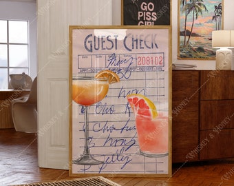 May include: A framed print depicting a vintage guest check with cocktail illustrations. One is an orange cocktail with an orange slice, the other a pink cocktail with a grapefruit slice. The text "GUEST CHECK" is visible in blue.
