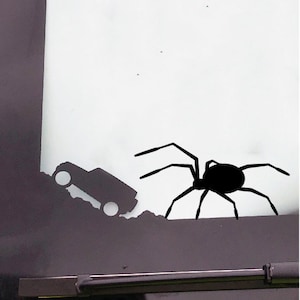 May include: A black silhouette of a spider with eight legs on a white background. A black silhouette of a car is partially visible in the lower left corner of the image.