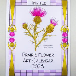 May include: A Prairie Flower Art Calendar 2026 featuring a thistle illustration. The calendar has a white background with a purple and gold border. The thistle is depicted with pink and yellow flowers and the word "Thistle" at the top.