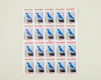 May include: Twenty-five vintage postage stamps featuring a bluebird with the text "IDAHO" and "USA 25 1890" repeated on each stamp.