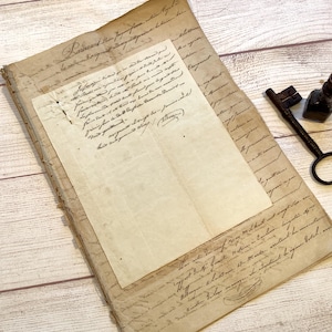 Puede incluir: Documentos antiguos con escritura manuscrita, superpuestos sobre una superficie de madera. Se ven una llave y un tintero antiguos. Los papeles están desgastados, lo que sugiere importancia histórica.