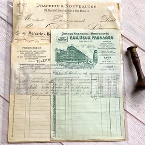 Pode incluir: Uma coleção de documentos franceses antigos, incluindo recibos e papelaria, com escrita manuscrita e texto impresso. Os papéis apresentam ilustrações arquitetónicas. Um carimbo de madeira e metal é visível à direita. Os papéis estão numa manga de plástico transparente.