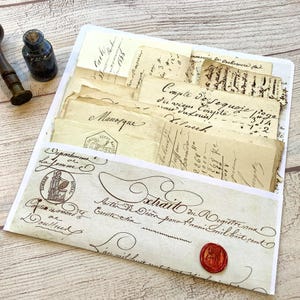 Könnte beinhalten: Eine offene weiße Umschlag gefüllt mit gealterten Papierdokumenten mit handschriftlicher Schrift und Stempeln. Ein rotes Wachssiegel ist sichtbar. Eine Tintenflasche und ein Holzstift befinden sich im Hintergrund. Vintage-Ephemera.