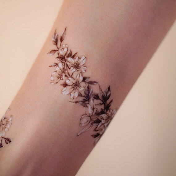 Black flowers tattooed on the arm  Tattoogridnet