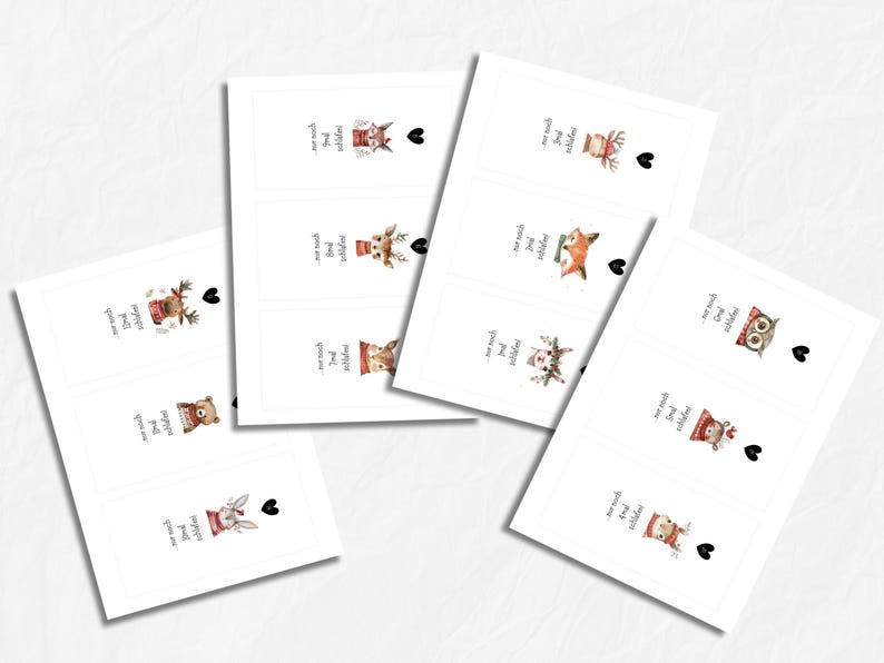 May include: White rectangular cards with watercolor illustrations of woodland animals, including a bear, fox, and owl, each wearing a winter hat. The cards have text and a black heart. The theme is likely related to winter or Christmas.