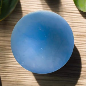 May include: A light blue, smooth, round, decorative bowl.