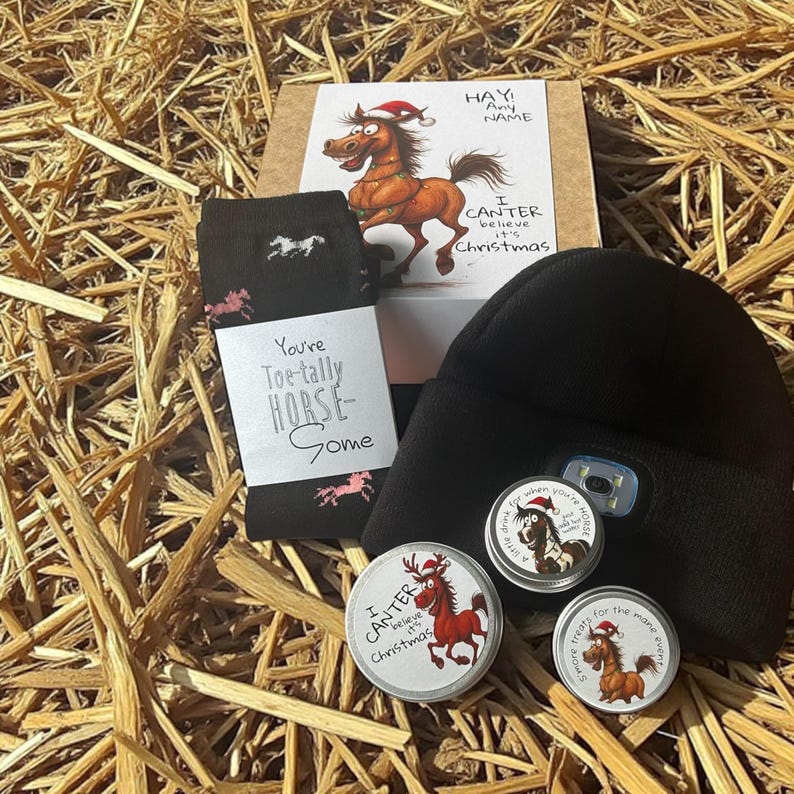 May include: A gift set with a Christmas theme, featuring a black beanie with a light, socks with horse silhouettes, and small tins. The set includes a card with a horse wearing a Santa hat and the text "I CANTER believe it's Christmas."