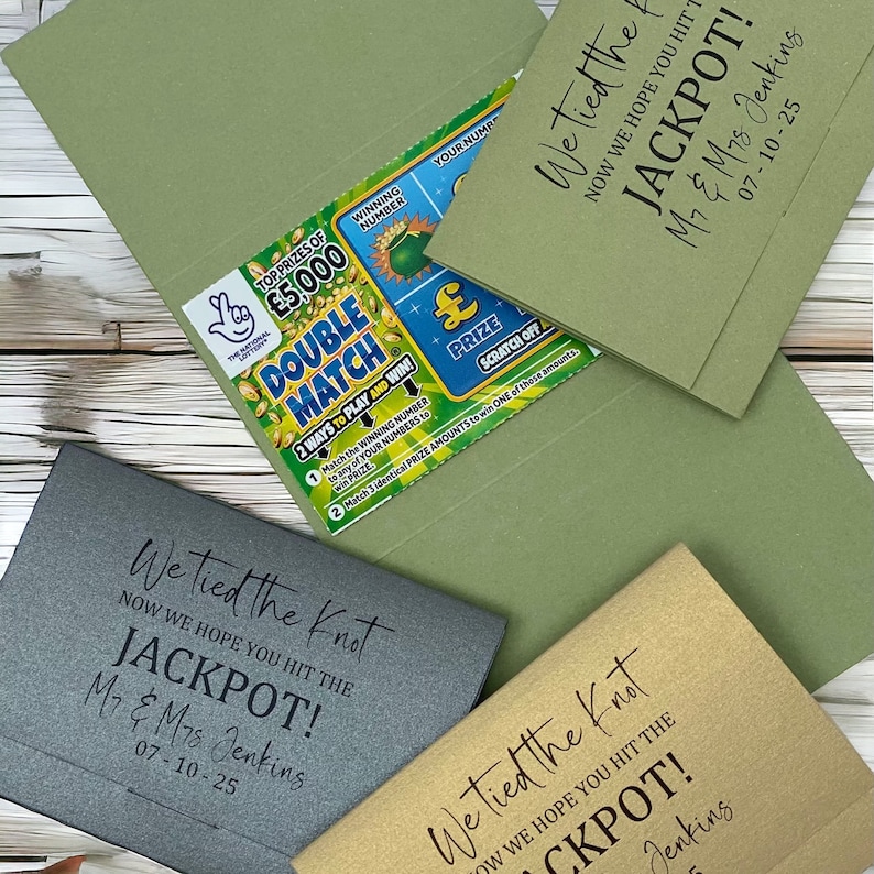 Puede incluir: Tres sobres verdes, dorados y grises con el texto "We tied the knot now we hope you hit the jackpot!" y la fecha "07-10-25". Los sobres est&aacute;n decorados con un boleto de loter&iacute;a.