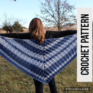 Pode incluir: Um xale de crochê em tons de azul e branco, pendurado em uma porta branca.
