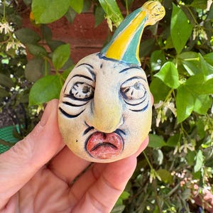 Puede incluir: Una taza de cerámica blanca con un asa negra y el texto "But First, Coffee" en negro, con una fuente de estilo manuscrito. La taza está sobre una superficie blanca.