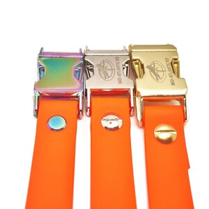 Puede incluir: Tres correas de perro de goma naranja con clips met&aacute;licos. Los clips est&aacute;n en diferentes acabados: arco&iacute;ris, plata y oro. Cada clip tiene el texto "MID-ATLANTIC K9" grabado.