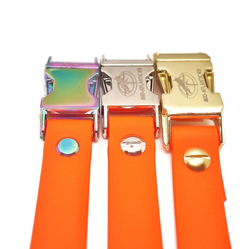 Puede incluir: Tres correas de perro de goma naranja con clips met&aacute;licos. Los clips est&aacute;n en diferentes acabados: arco&iacute;ris, plata y oro. Cada clip tiene el texto "MID-ATLANTIC K9" grabado.