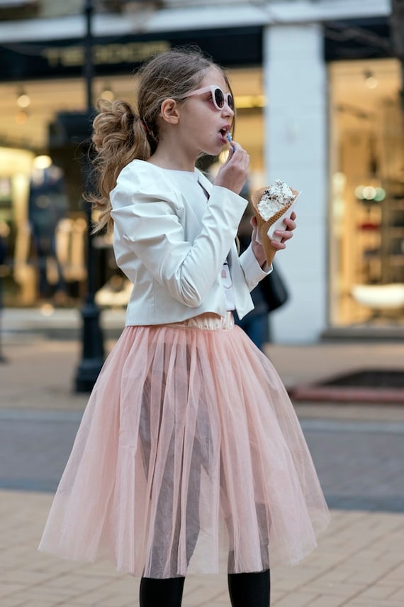 Young curled girl weared in tulle skirt and red leather jacket