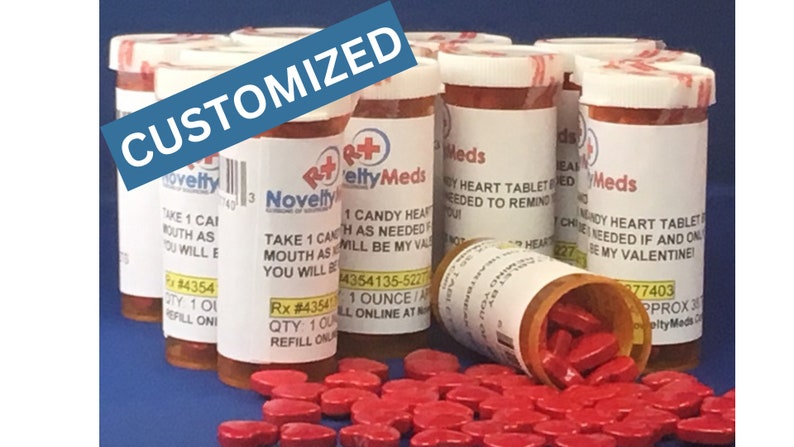May include: A group of six red and white pill bottles with custom labels that say "Candy Heart Tablet" and "Mundy Heart Tablet". The bottles are filled with red heart-shaped candy. The text on the labels reads "Take 1 Candy Heart as needed. Will be my Valentine!" and "Take 1 Mundy Heart Tablet as needed if and only if you will be my Valentine!"