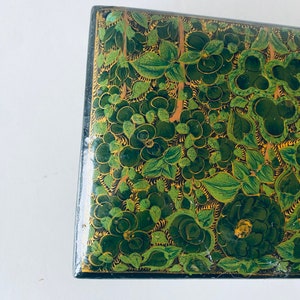 K&ouml;nnte beinhalten: Eine gr&uuml;n und gold bemalte Holzkiste mit einem floralen Design. Die Kiste ist mit komplizierten Details verziert und hat einen traditionellen indischen Stil.