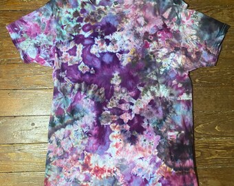 May include: A tie-dye t-shirt with a purple, pink, blue, and black color scheme. The shirt has a swirling pattern with a variety of shades of each color.