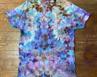 May include: A short-sleeved t-shirt with a tie-dye pattern in shades of blue, purple, and brown. The shirt is made of a soft material and has a crew neck. The tie-dye design creates a unique and colorful look.