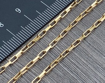Pode incluir: Um close-up de um colar de corrente de ouro com um design de corrente de caixa. A corrente está colocada sobre uma régua com marcas em polegadas.