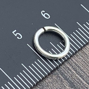 May include: A silver jump ring measuring 5/16 inches in diameter.