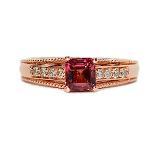 May include: A rose gold ring with a square-shaped pink gemstone surrounded by smaller diamonds.
