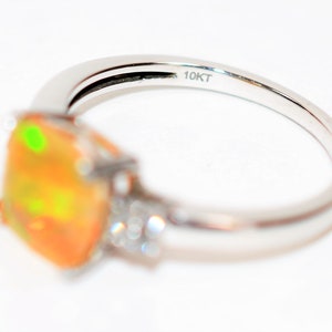 May include: A gold ring with a large orange opal gemstone and smaller diamonds on the band. The ring is marked "10KT" on the inside.