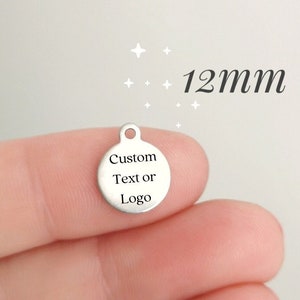 May include: A silver round charm with a hole at the top. The charm is 12 mm in diameter and has the text "Custom Text or Logo" engraved on it.