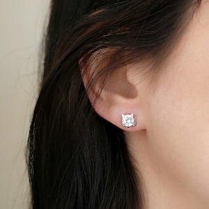 May include: A pair of silver cat-shaped stud earrings with clear cubic zirconia stones.