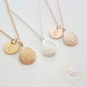 May include: Three necklaces with a seashell charm and a personalised initial disc. The necklaces are available in gold, silver, and rose gold. The initial discs are engraved with the letters C, E, and a blank disc.