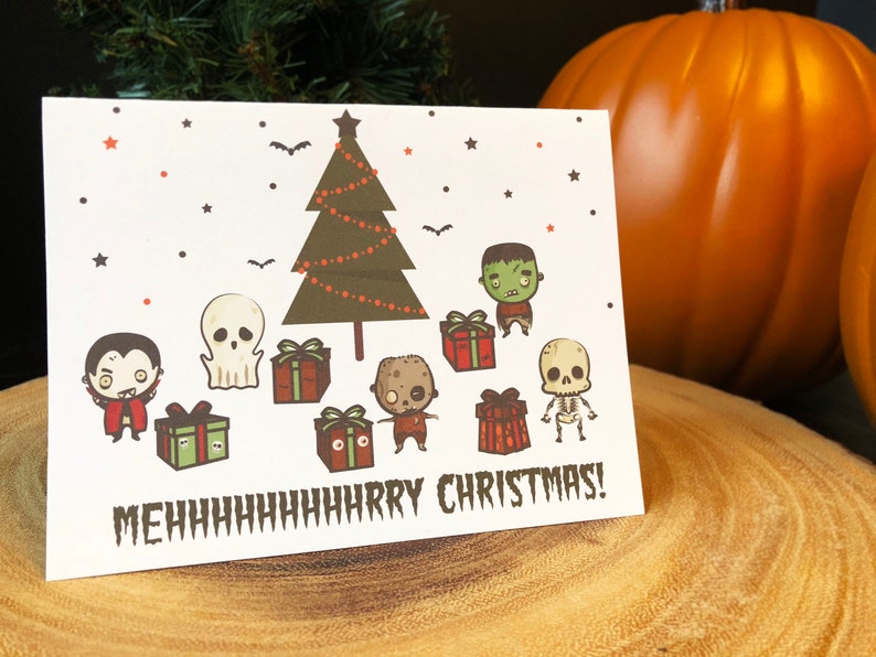 May include: A white Christmas card with a green Christmas tree, a vampire, a ghost, a zombie, a skeleton, and presents. The text on the card reads "MEHhhhhhhHARRY CHRISTMAS!"